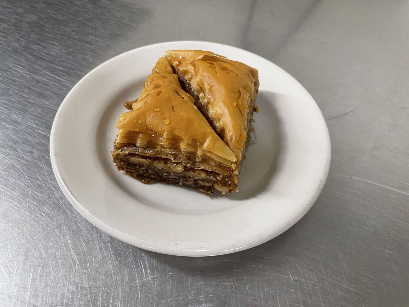 A white plate with a piece of baklava on it.