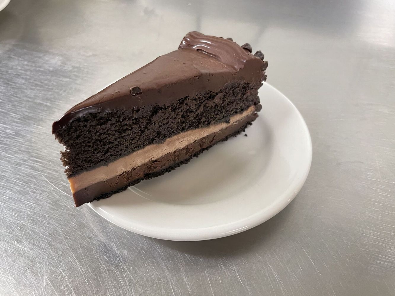 A slice of chocolate cake is on a white plate.