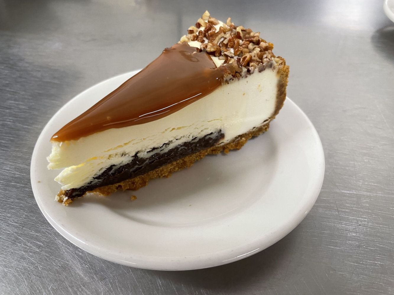 A slice of cheesecake is on a small white plate.