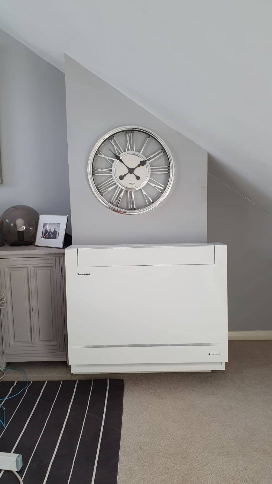 A large AC unit in a bedroom/converted loft.