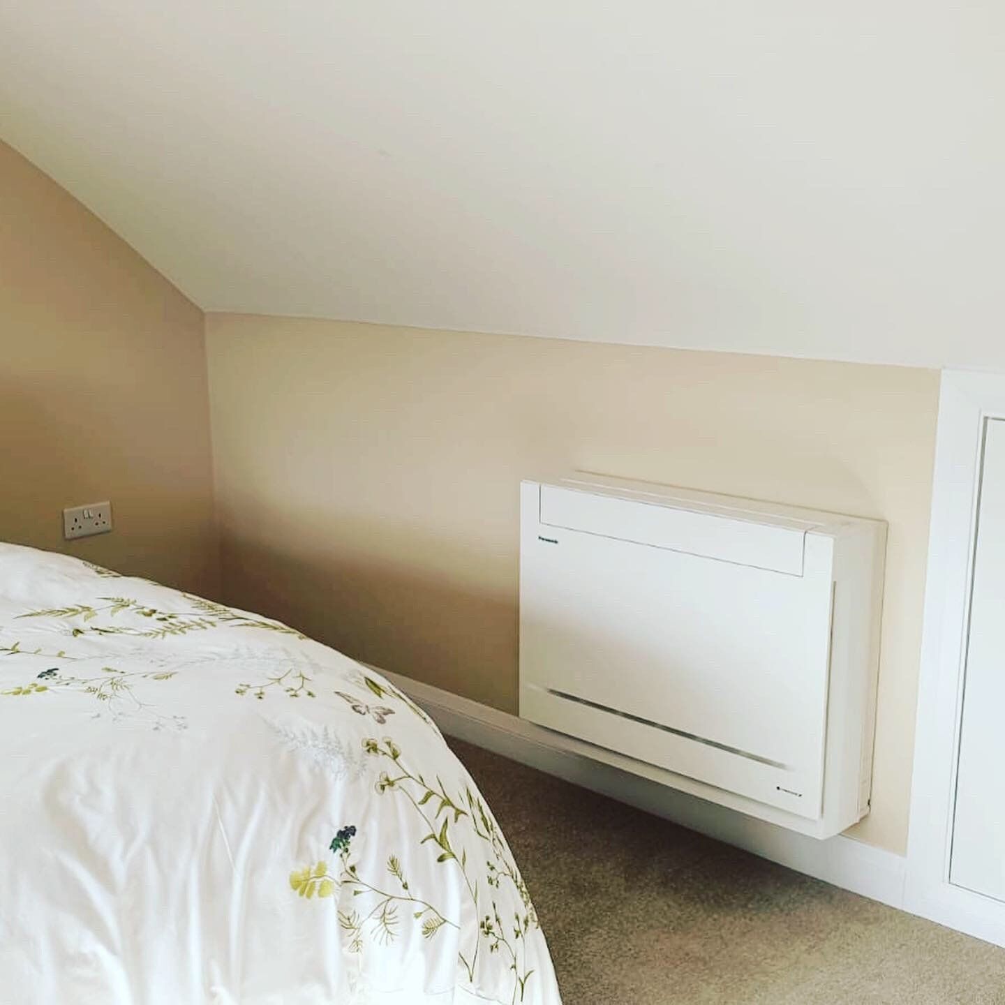 A wall-mounted AC unit in a converted loft space.