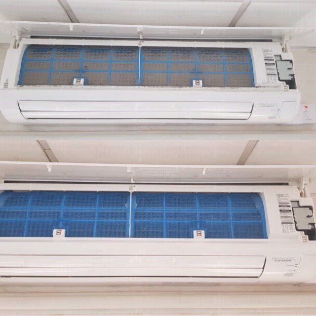 Two wall-mounted AC units; one on top of the other.