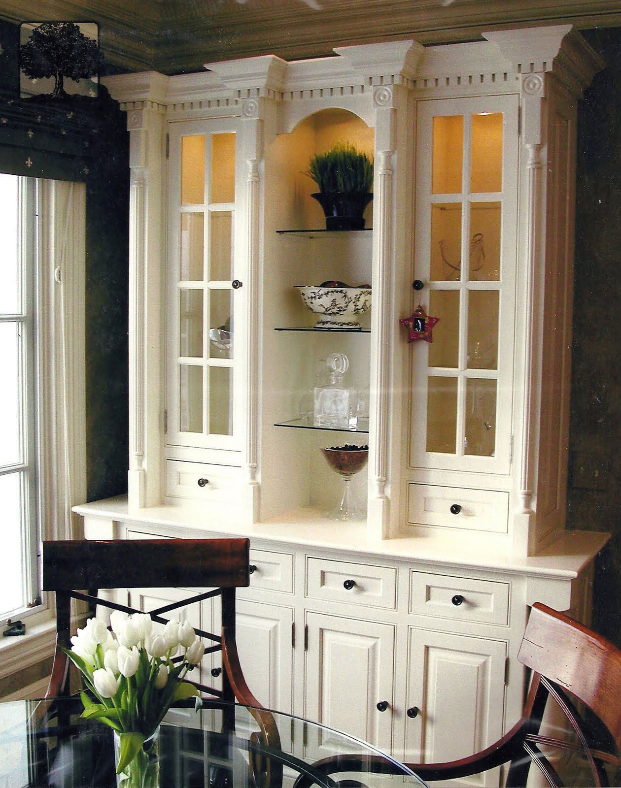 a dining room with white cabinets and a glass table
