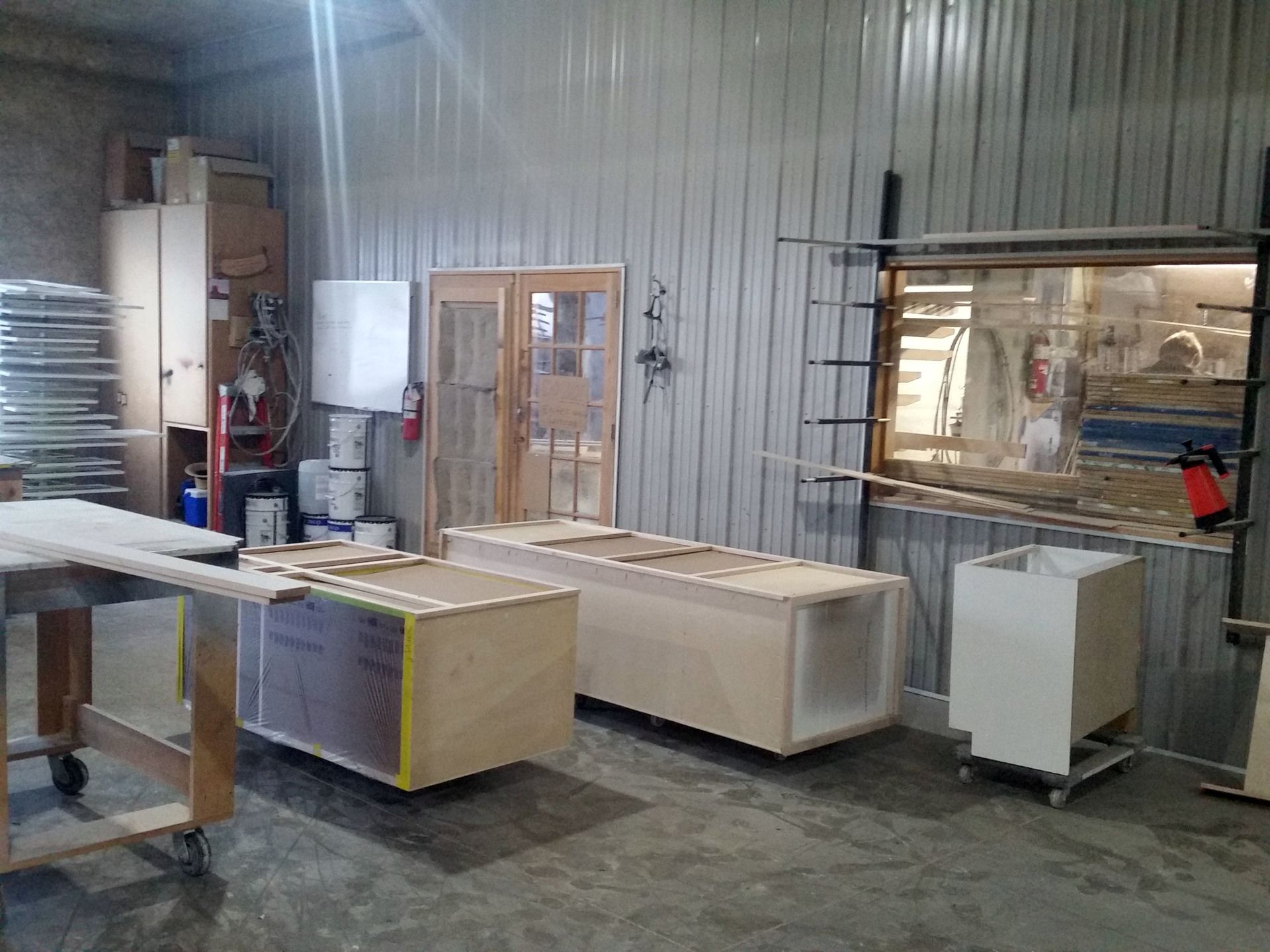 a room filled with lots of wooden boxes and a vacuum cleaner.