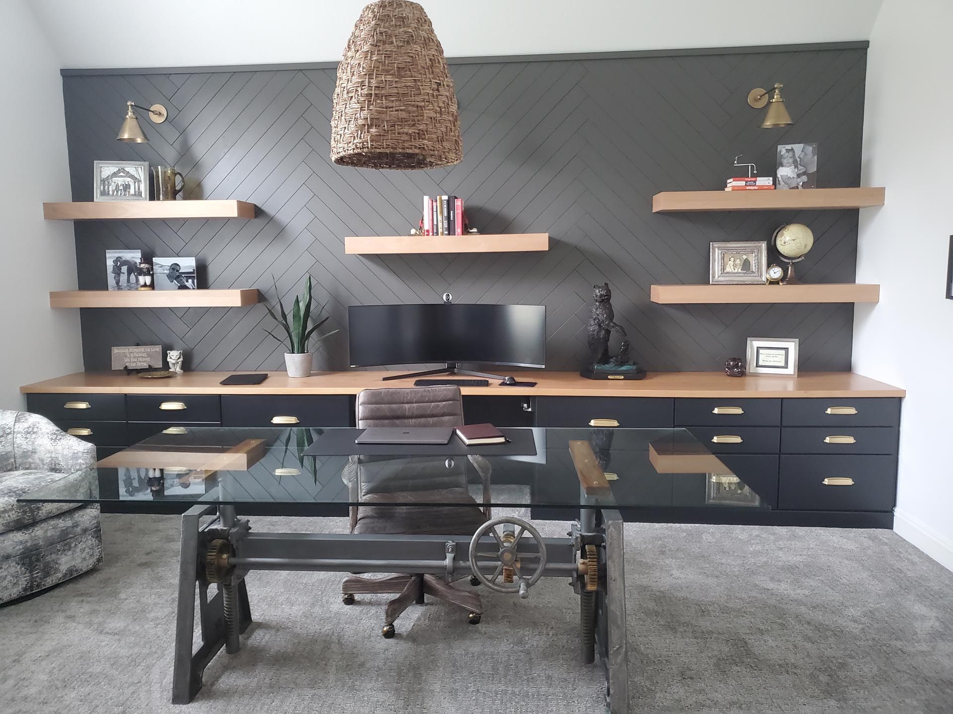 a home office with a desk , chair , shelves and a computer .