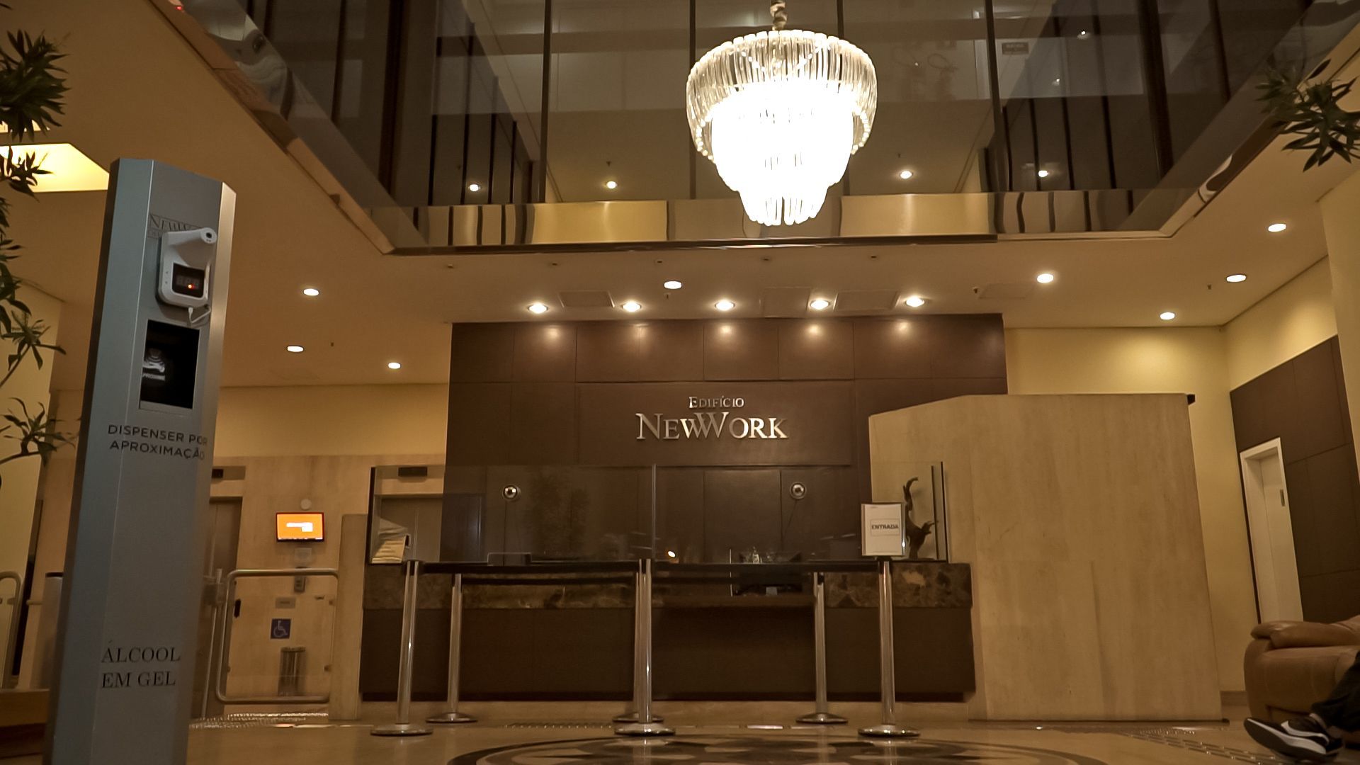 Lobby de hotel com lustre pendurado no teto.