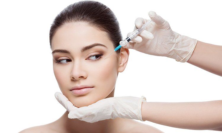 Uma mulher está recebendo uma injeção de botox no rosto.