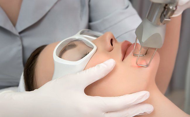 Uma mulher está fazendo um tratamento a laser no rosto.