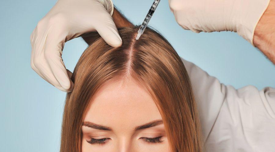 Uma mulher está recebendo uma injeção no cabelo.