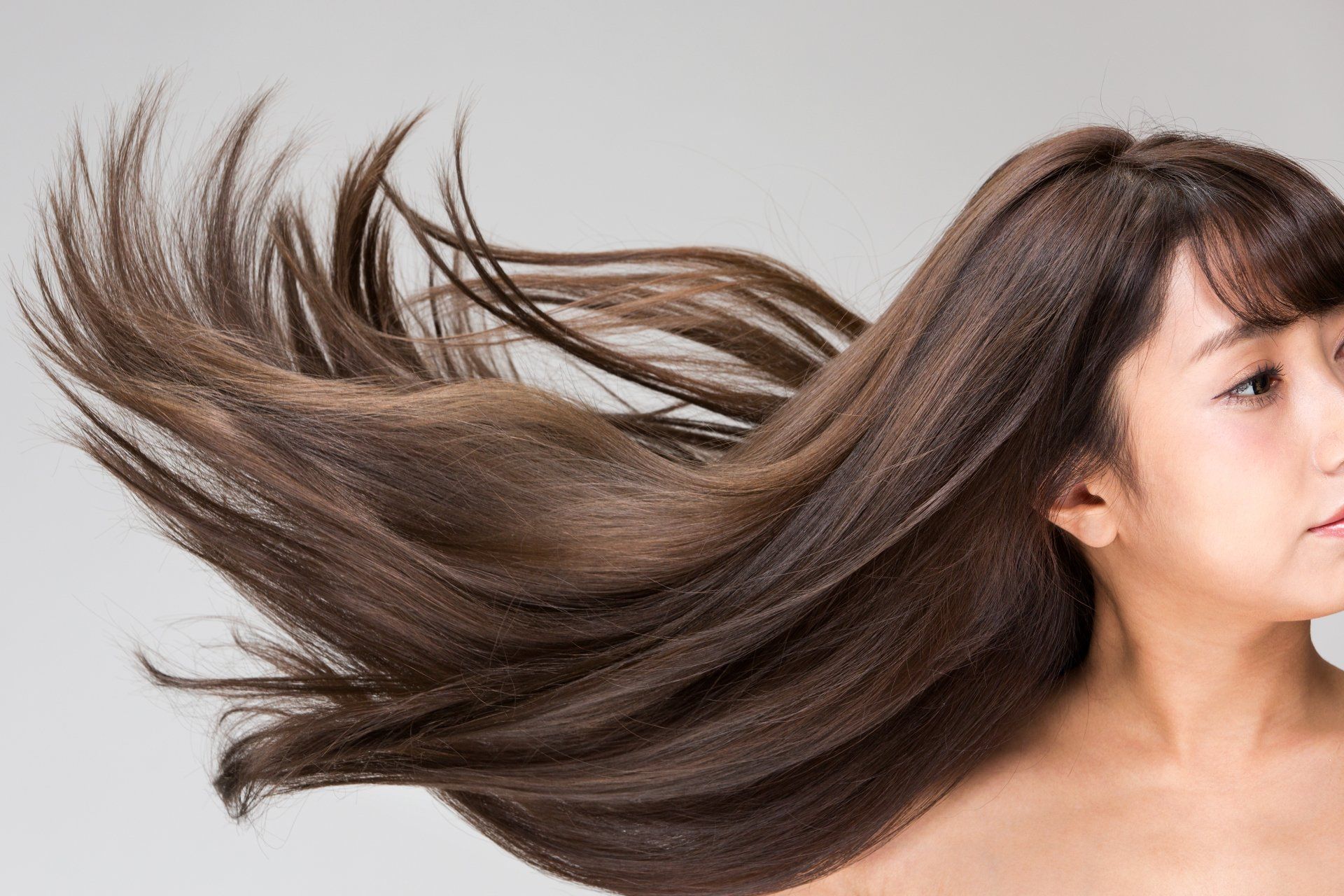 Uma mulher com cabelos longos está soprando no vento.