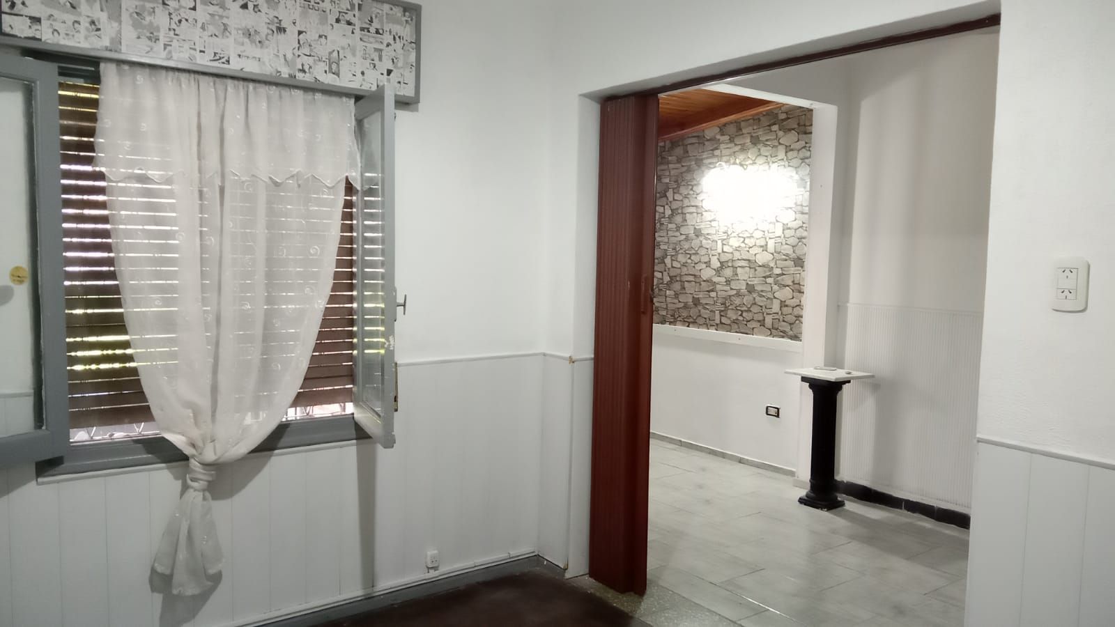 Exterior de edificio blanco con ventanas enrejadas y techo de madera.