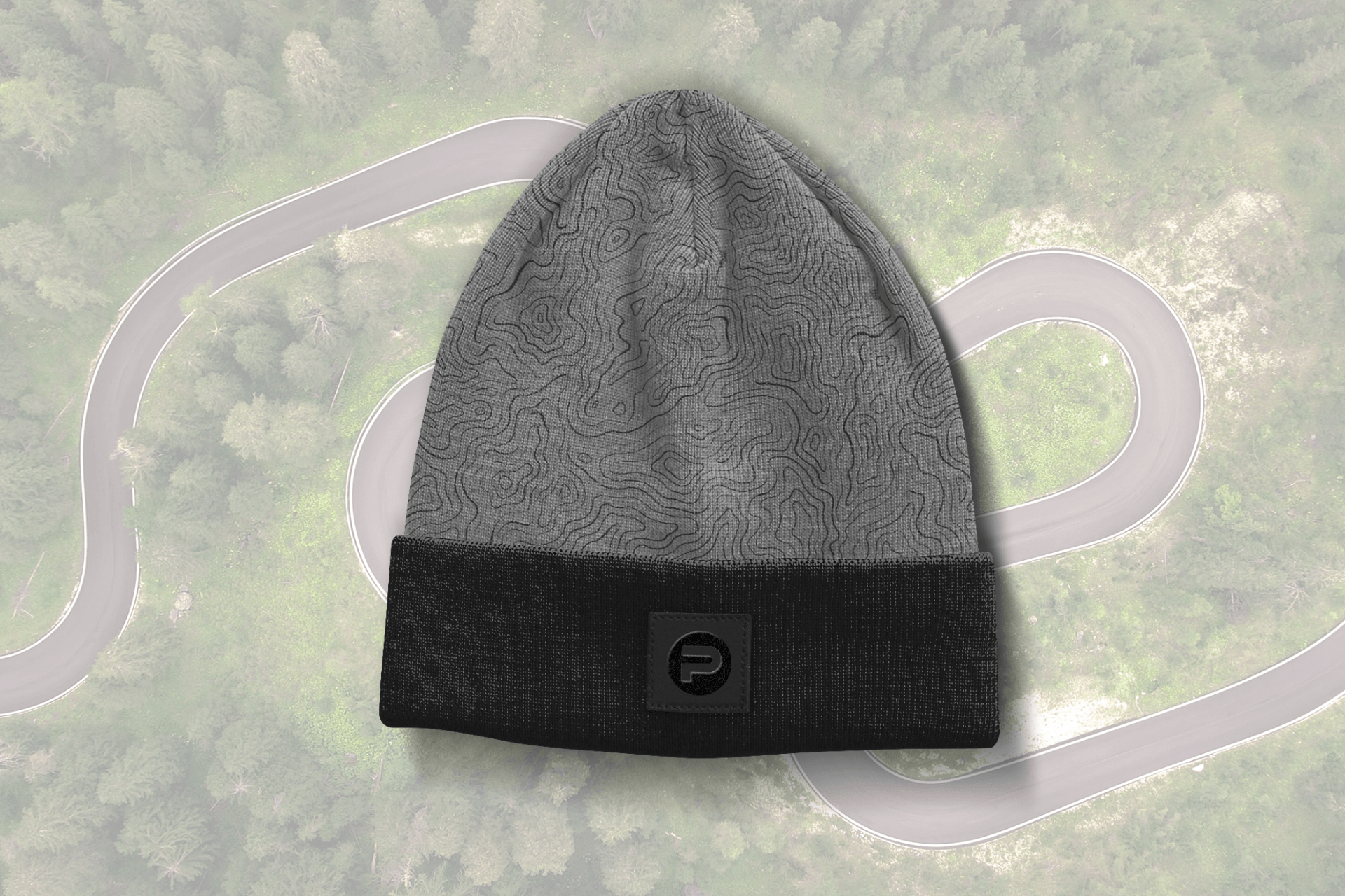 A gray and black beanie is sitting on top of a map of a road.