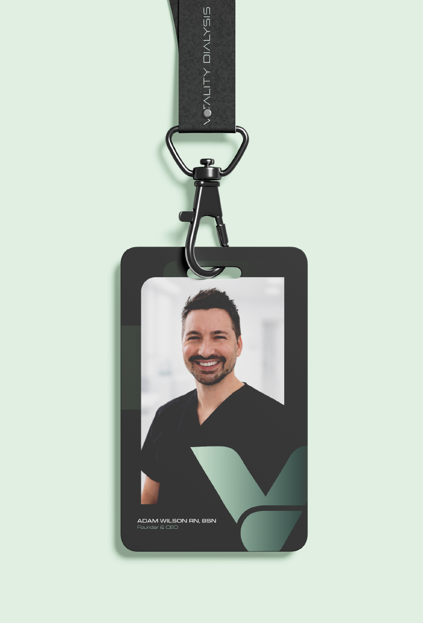 An identification badge on a black lanyard featuring a smiling man in a dark scrub top against a light background.
