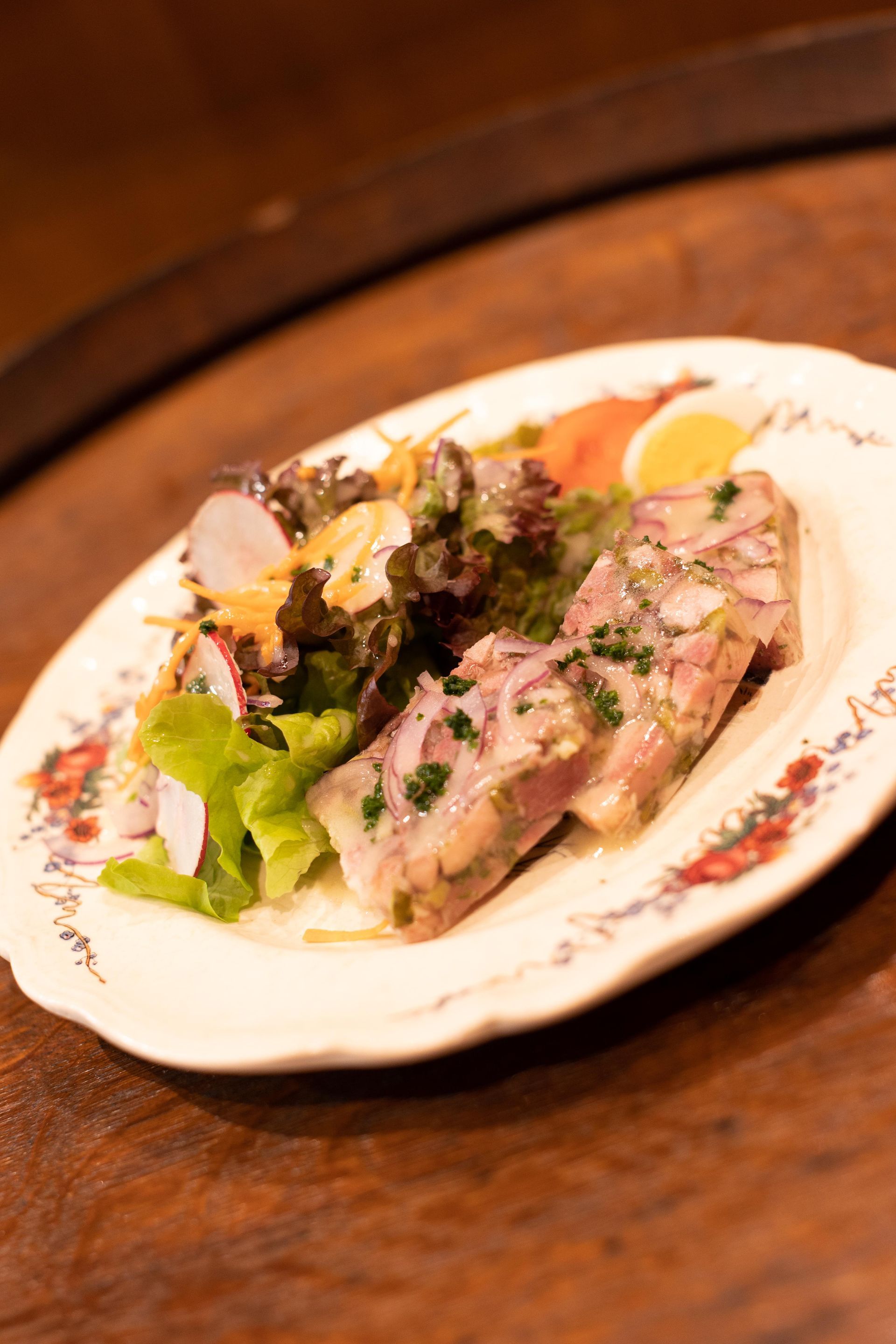 Une assiette de nourriture avec de la viande et des légumes sur une table en bois.
