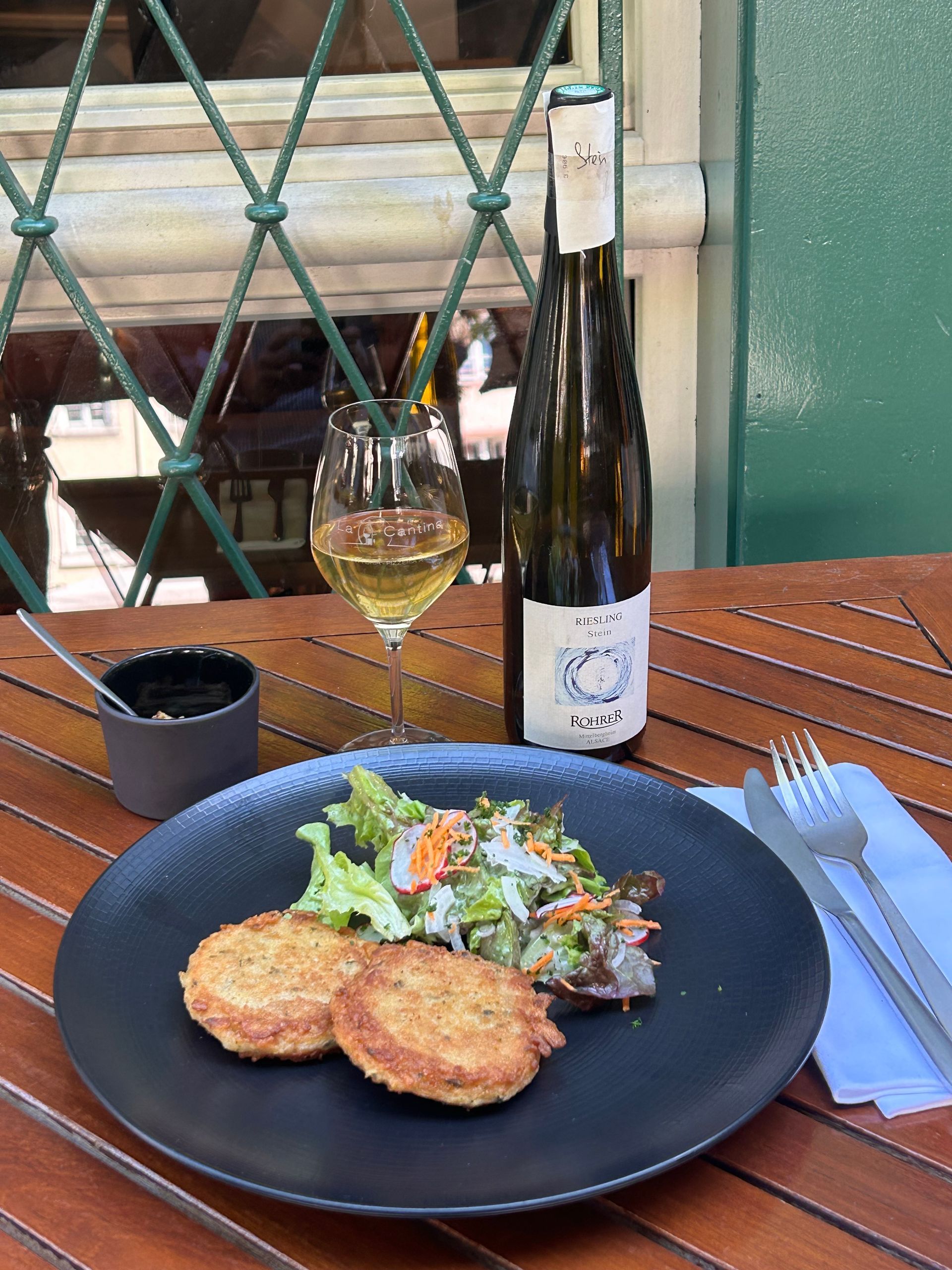 Une assiette de nourriture et une bouteille de vin sur une table