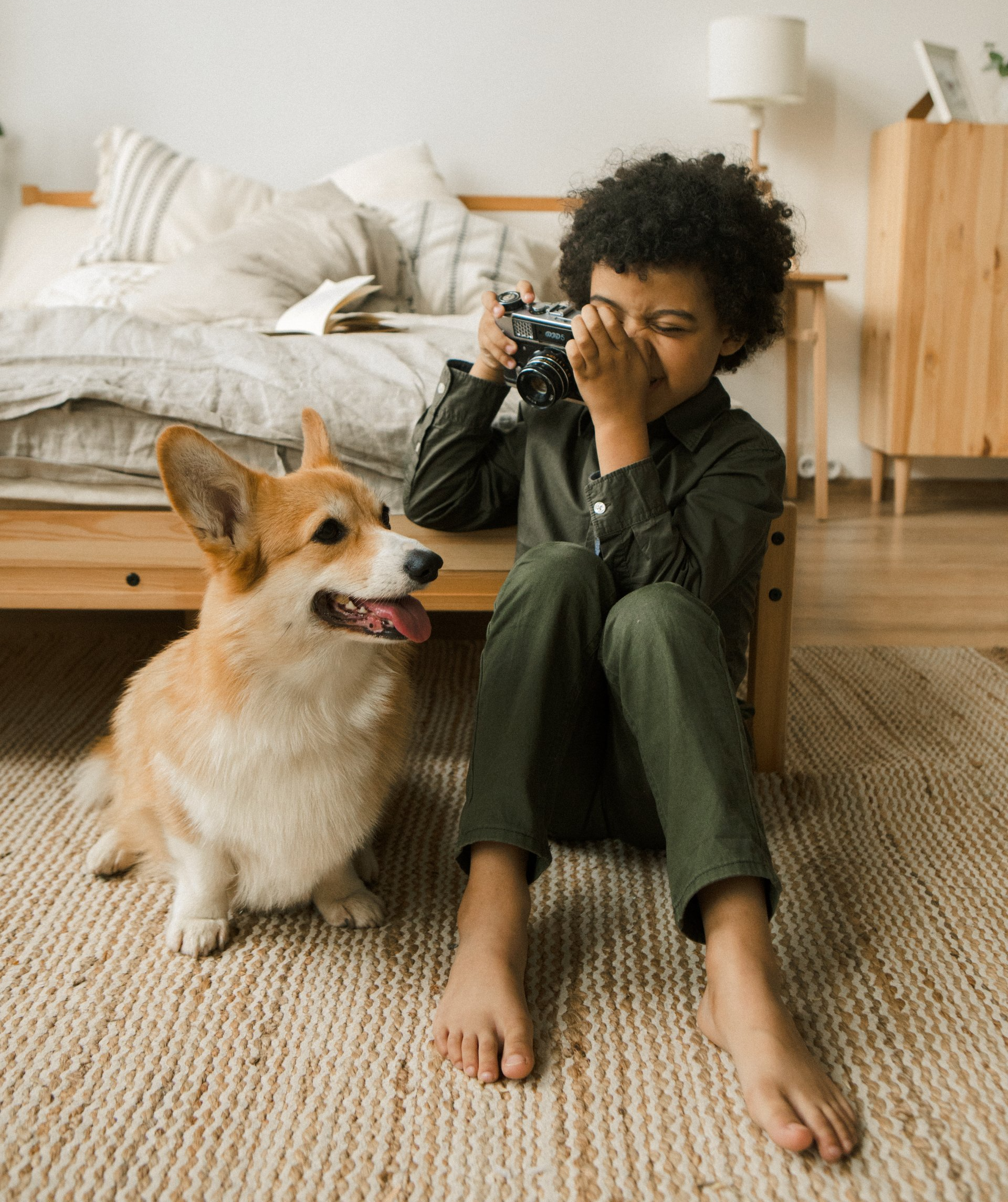 Boy taking photo of his pet corgi