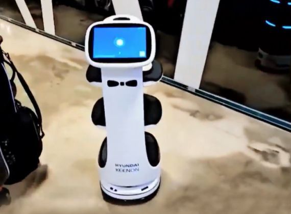 White Hyundai robot with a screen, in a modern setting.