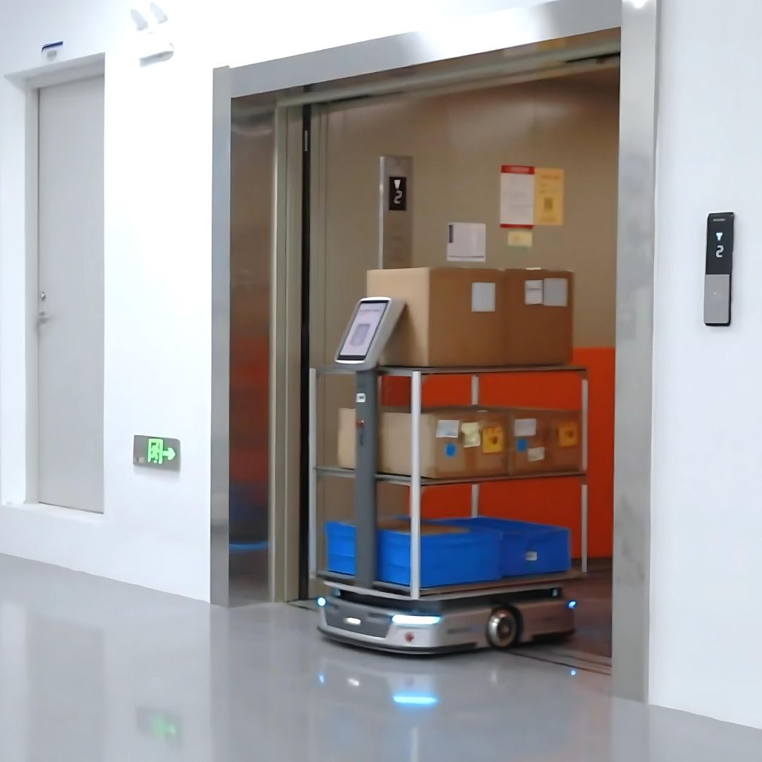 Robot carrying packages exiting elevator.