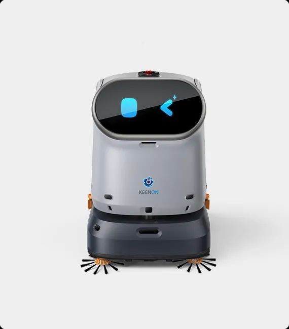 Robot vacuum cleaner on a gray floor, blue casing, cleaning near a white wall.