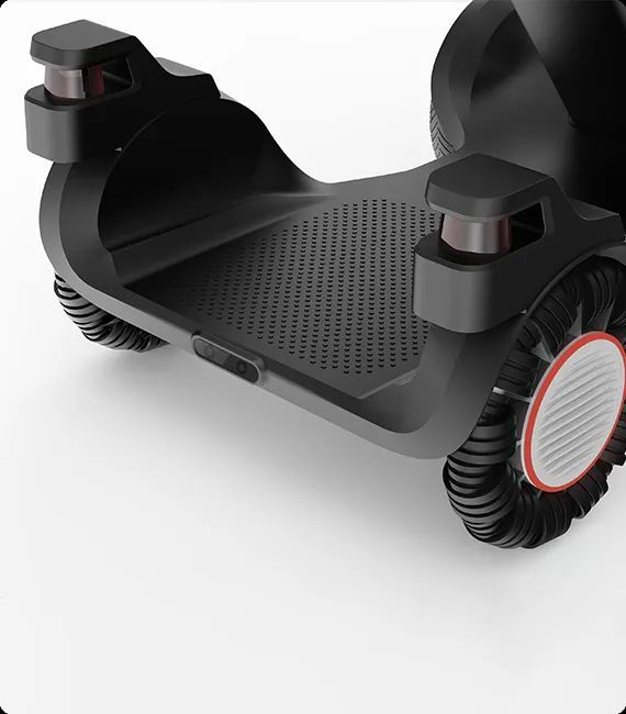 Black robotic platform with textured footrest, two small wheels, and two small sensors.