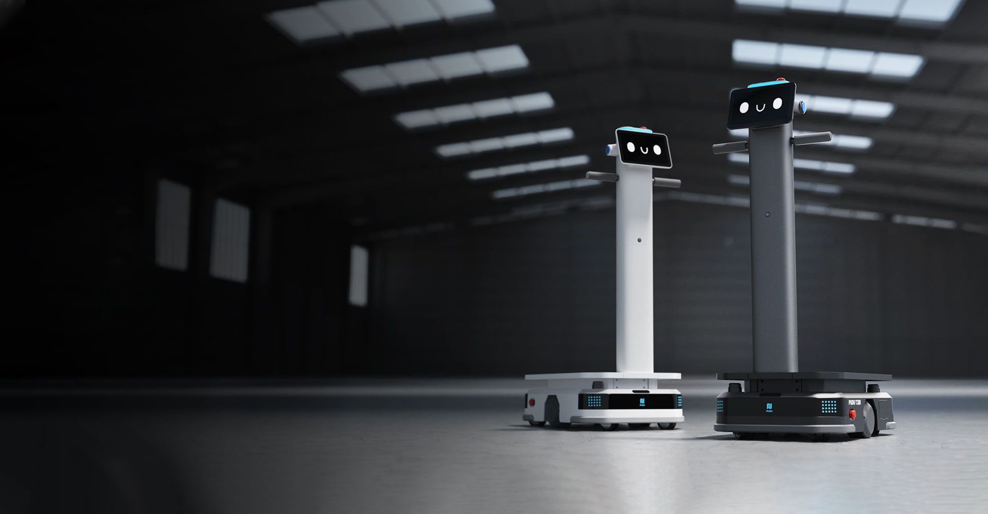 Two industrial robots in a dark warehouse setting. One is white, the other dark gray, with lit screens.