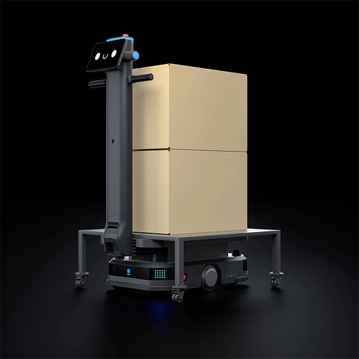 Mobile robot carrying two stacked cardboard boxes, dark background.