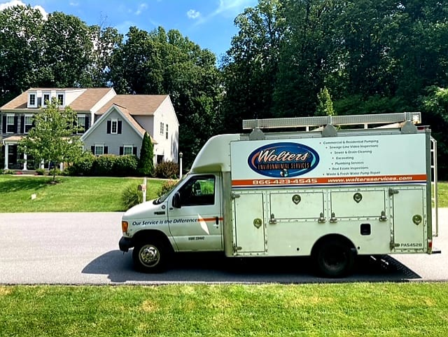 A white van from walters plumbing is parked in front of a house