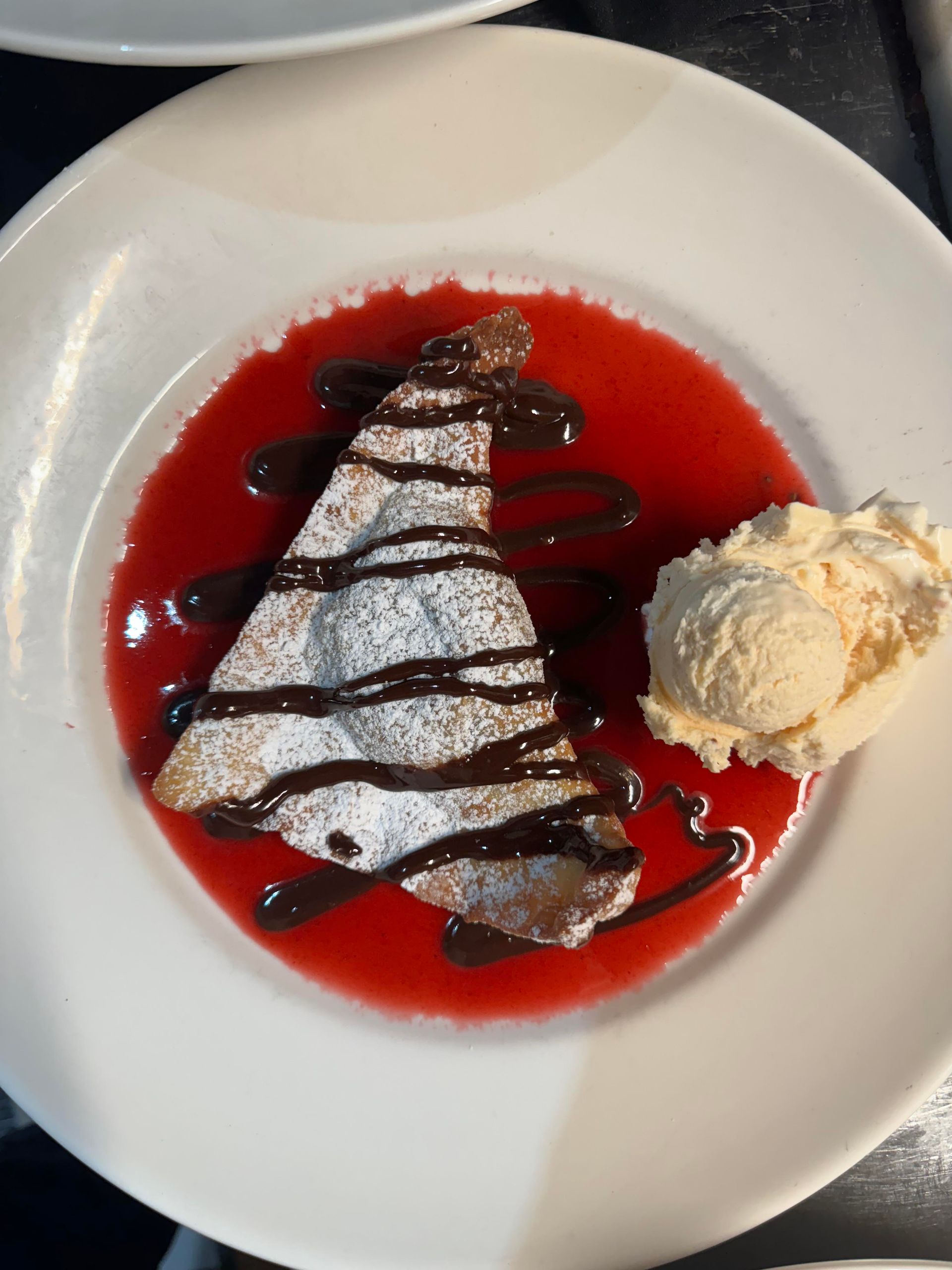 A white plate topped with a dessert and ice cream