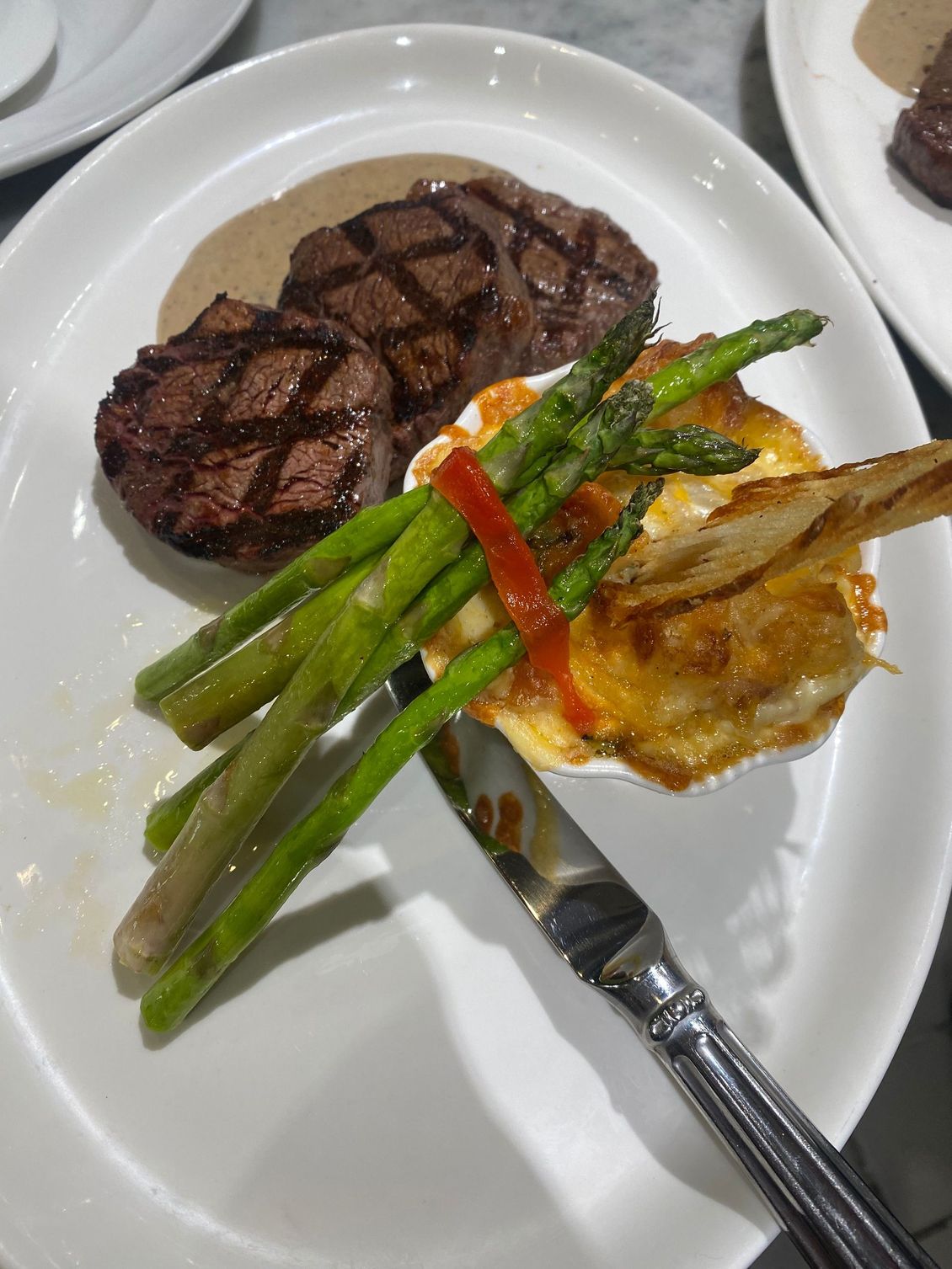 A plate of food with asparagus and steak on it