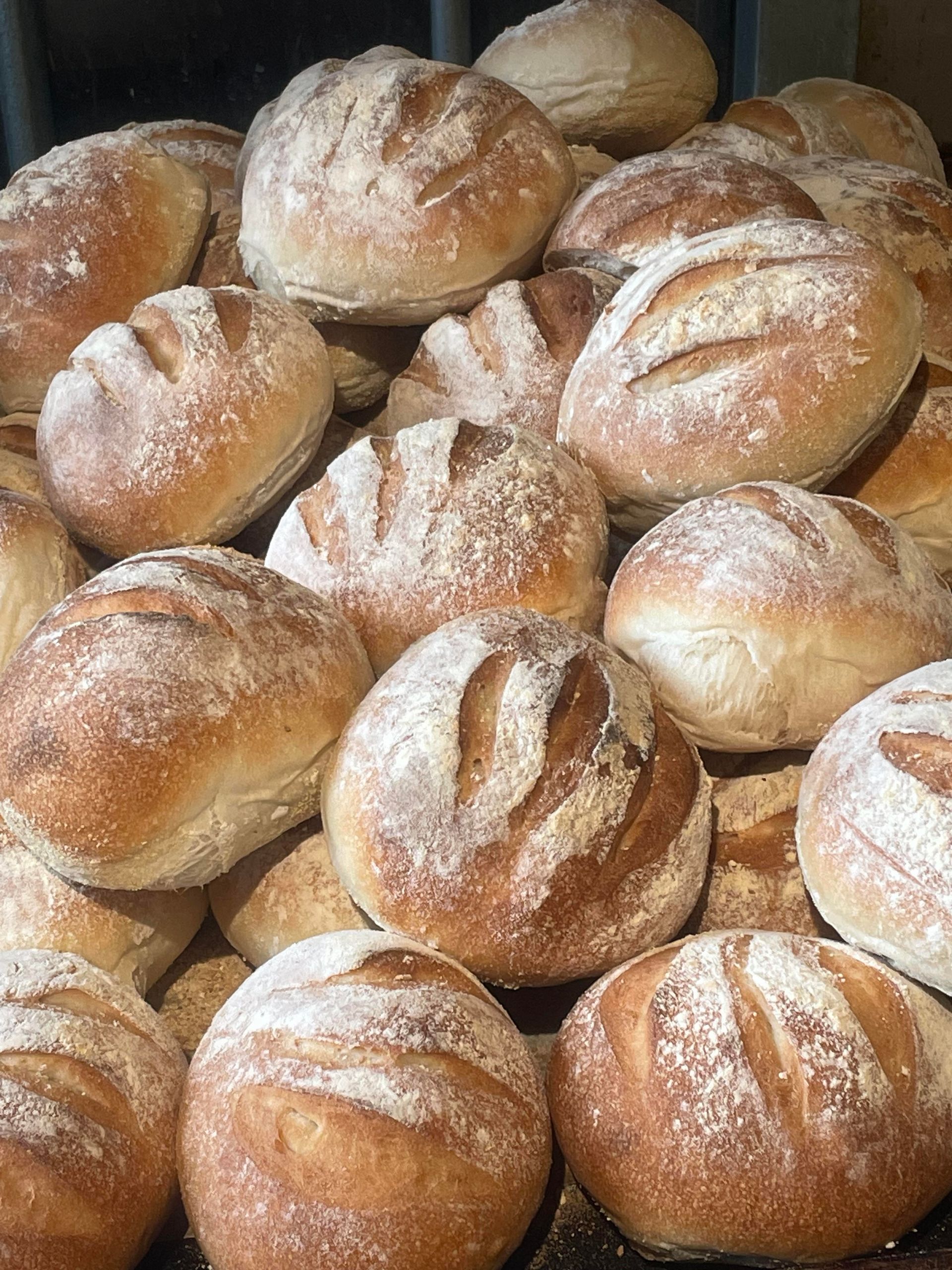 A bunch of bread rolls are sitting on top of each other on a table.