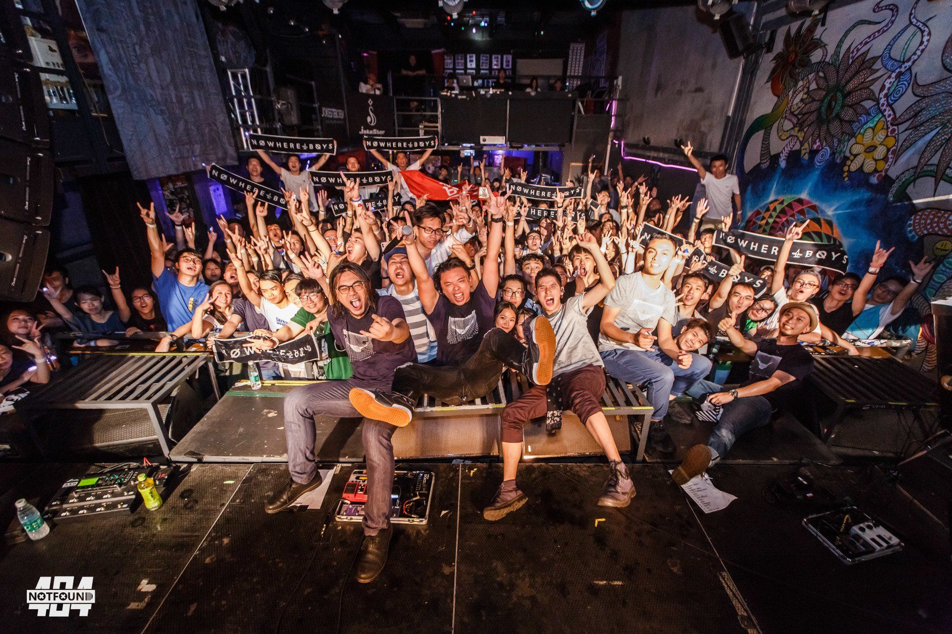 A large group of people are posing for a picture at a concert.