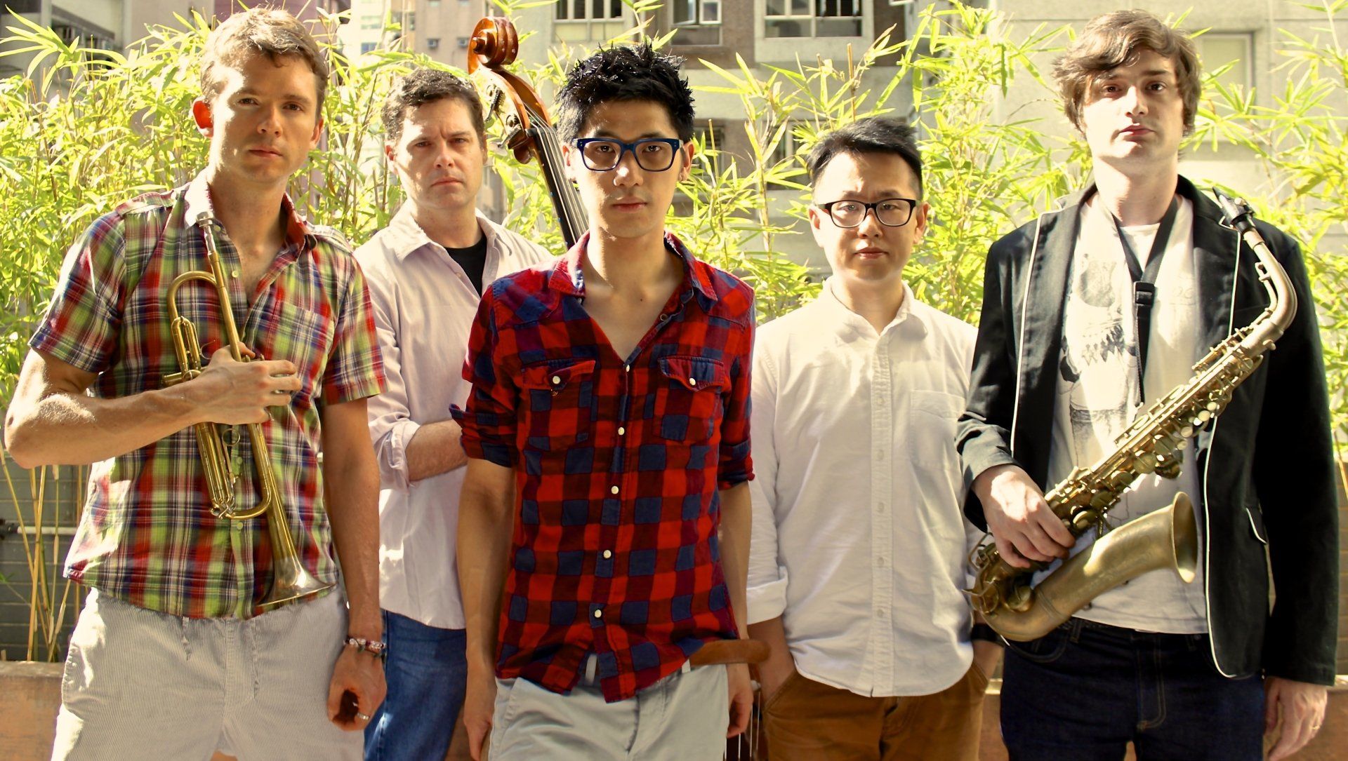 A group of young men standing next to each other holding musical instruments.