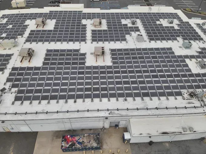 Large commercial building roof covered in solar panels.