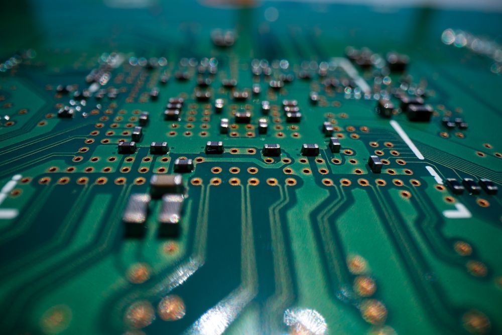 A close up of a green motherboard with lots of electronic components on it.