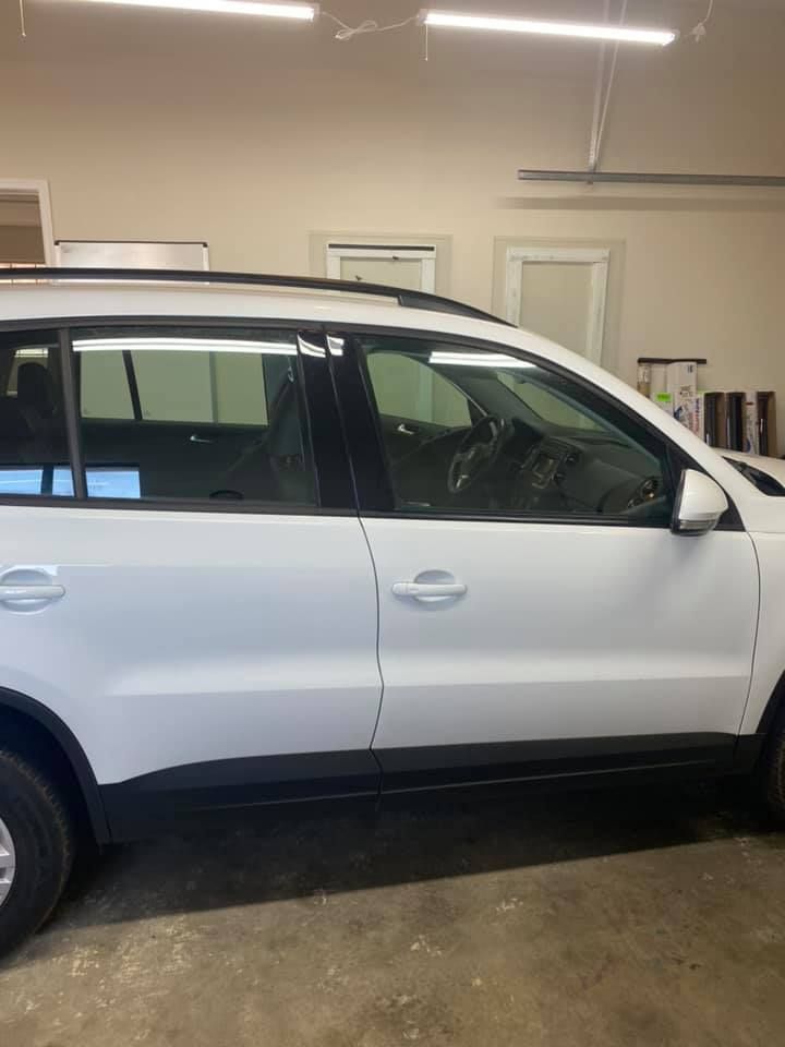 White SUV parked inside a garage. The vehicle has tinted windows.