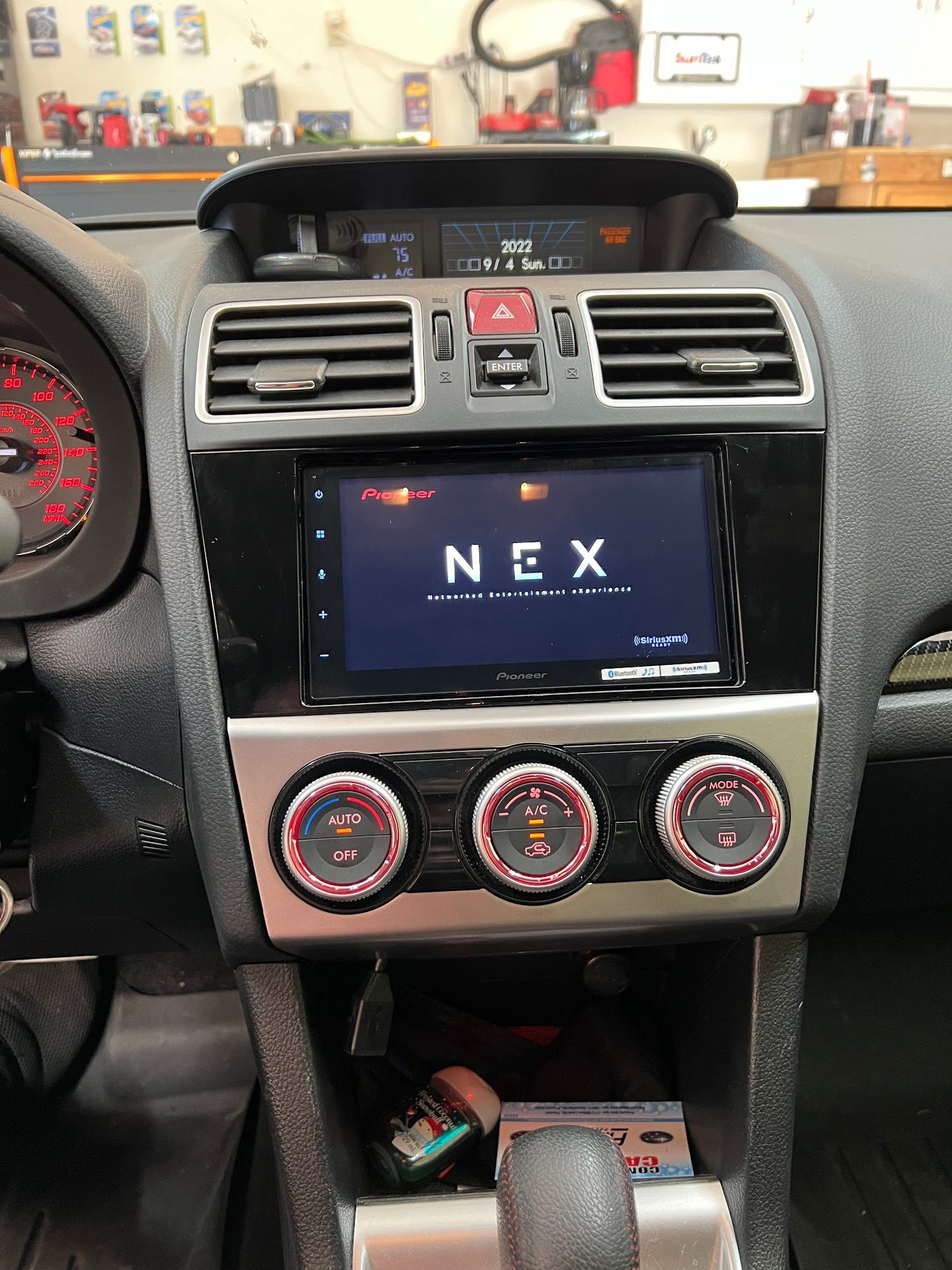 Car dashboard with a Pioneer NEX touchscreen display, black and silver trim, and illuminated gauges.