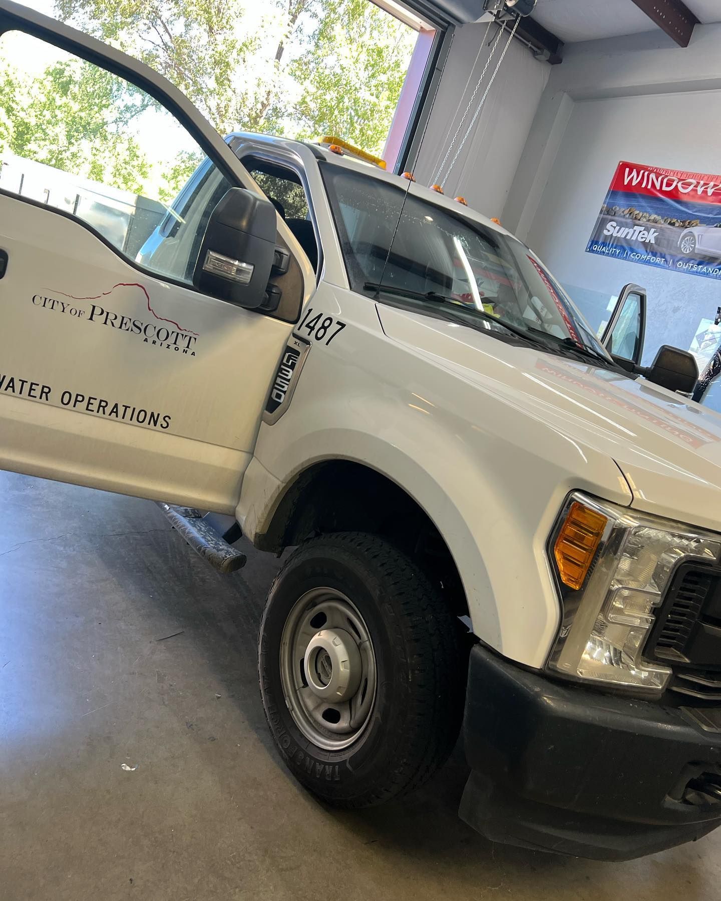 White truck with the door open, labeled 