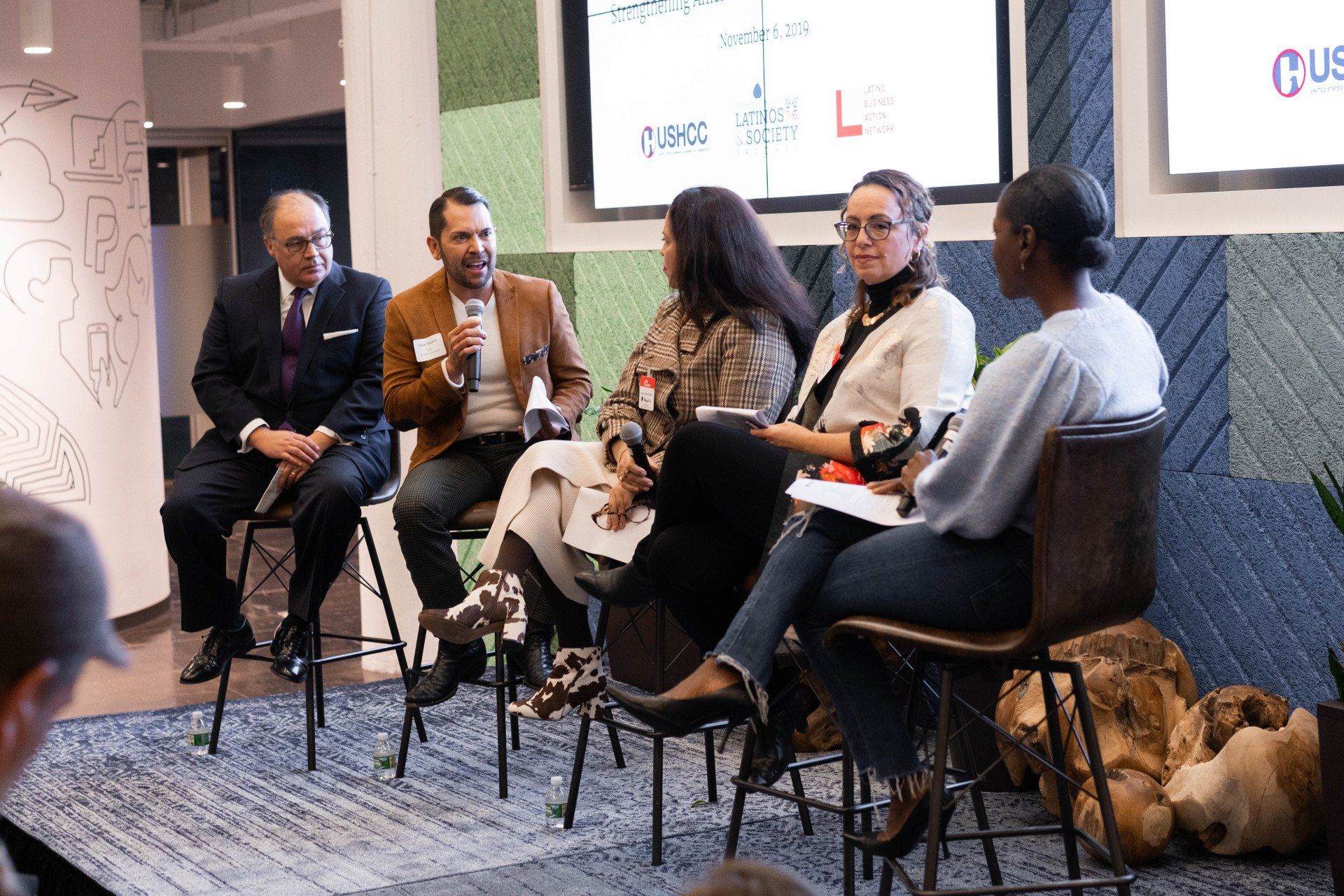 A group of people are sitting in chairs in front of a screen.