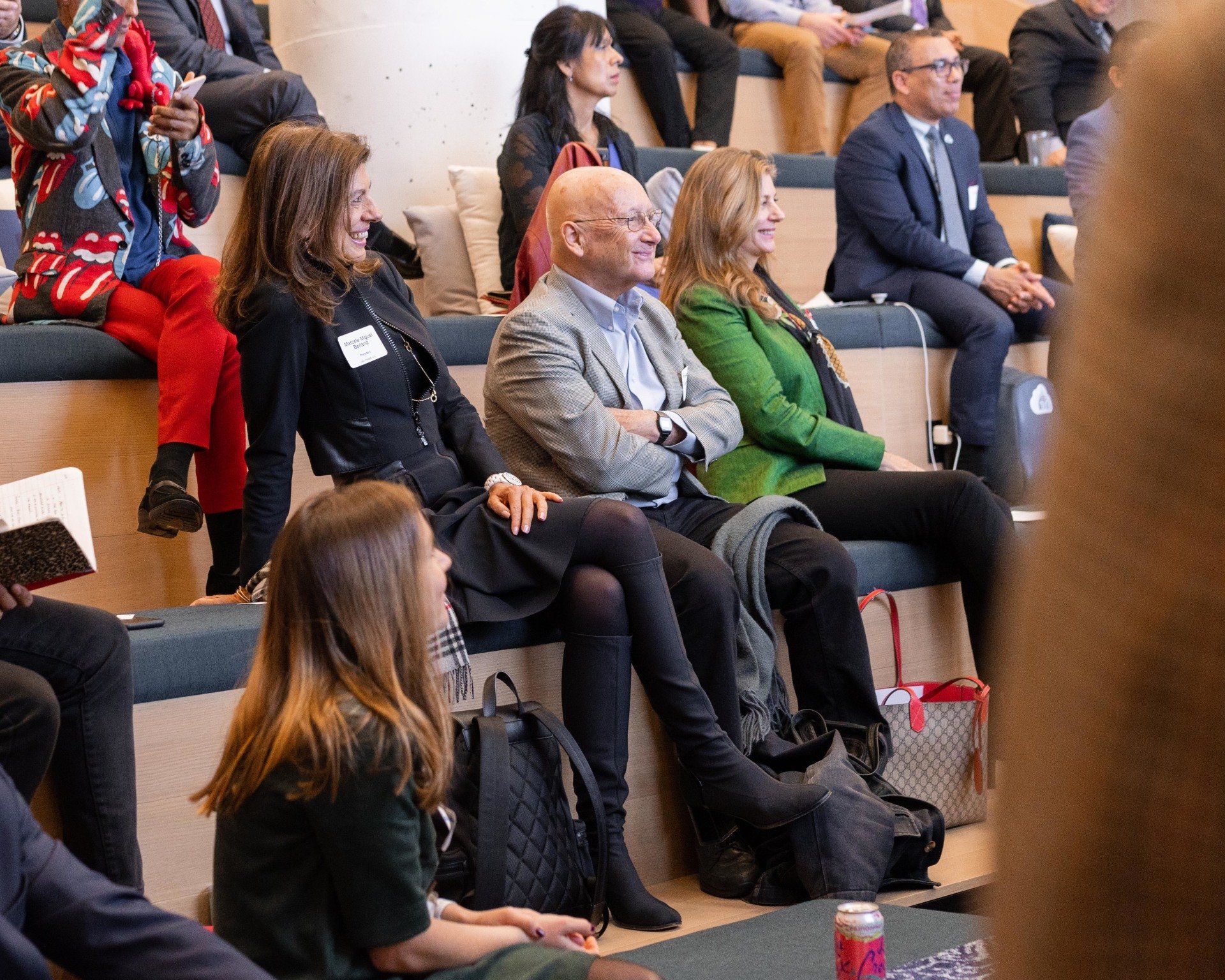 A group of people are sitting in an auditorium watching a presentation.