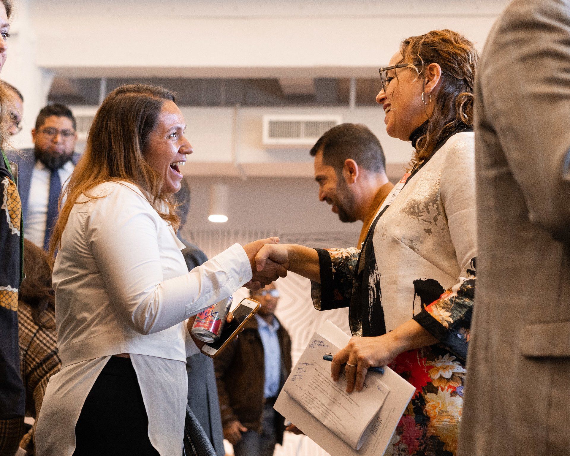 A group of people are shaking hands in a room.
