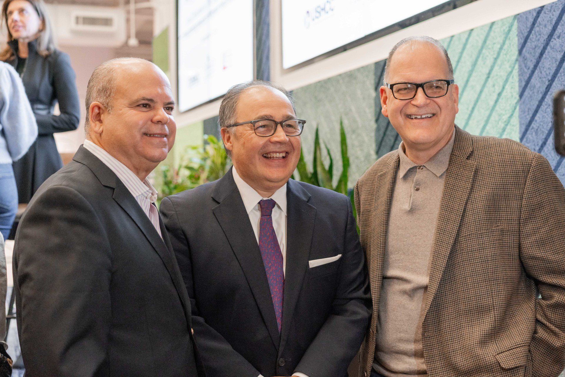 Three men in suits and ties are posing for a picture.