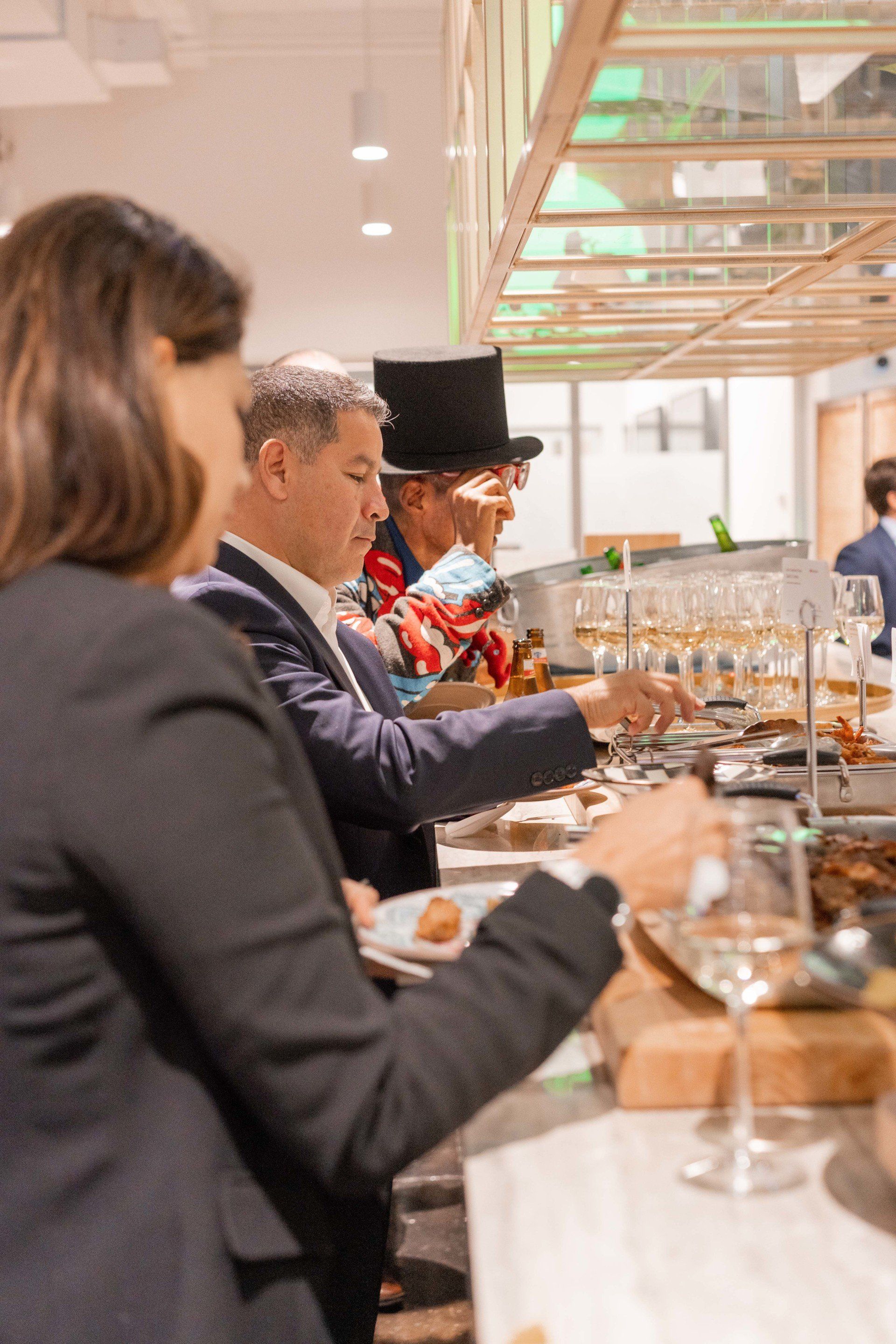 A group of people are sitting at a table eating food and drinking wine.