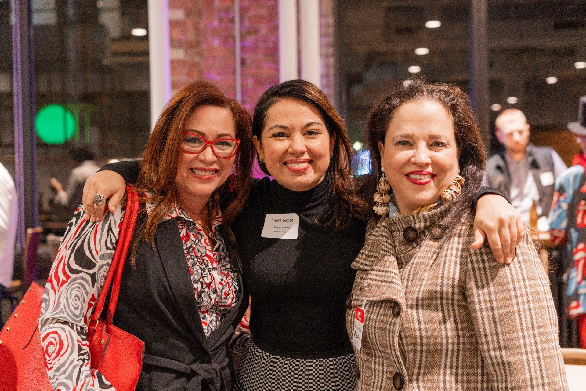 Three women are posing for a picture together in a room.
