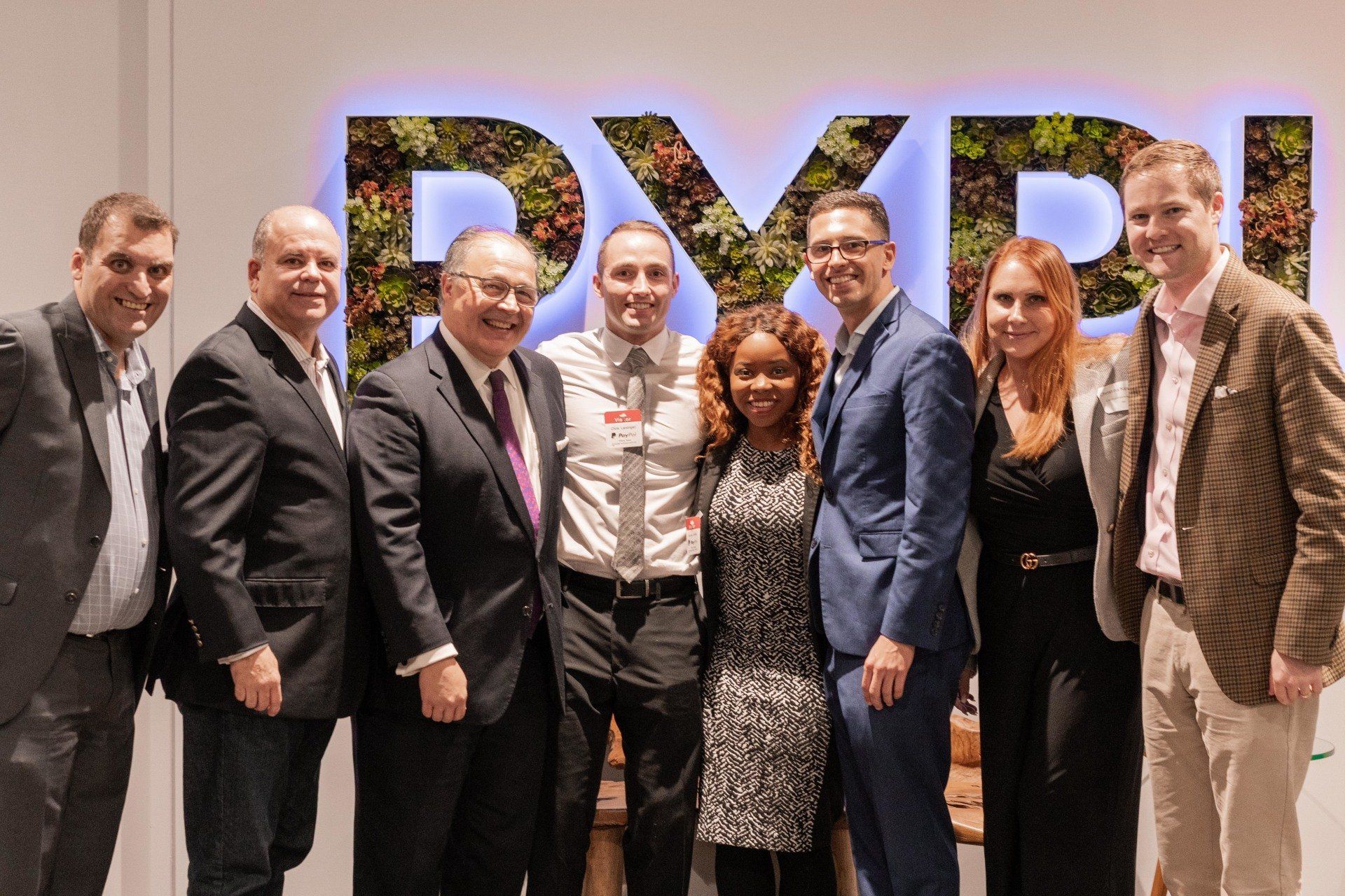 A group of people are posing for a picture in front of a sign that says pypi.