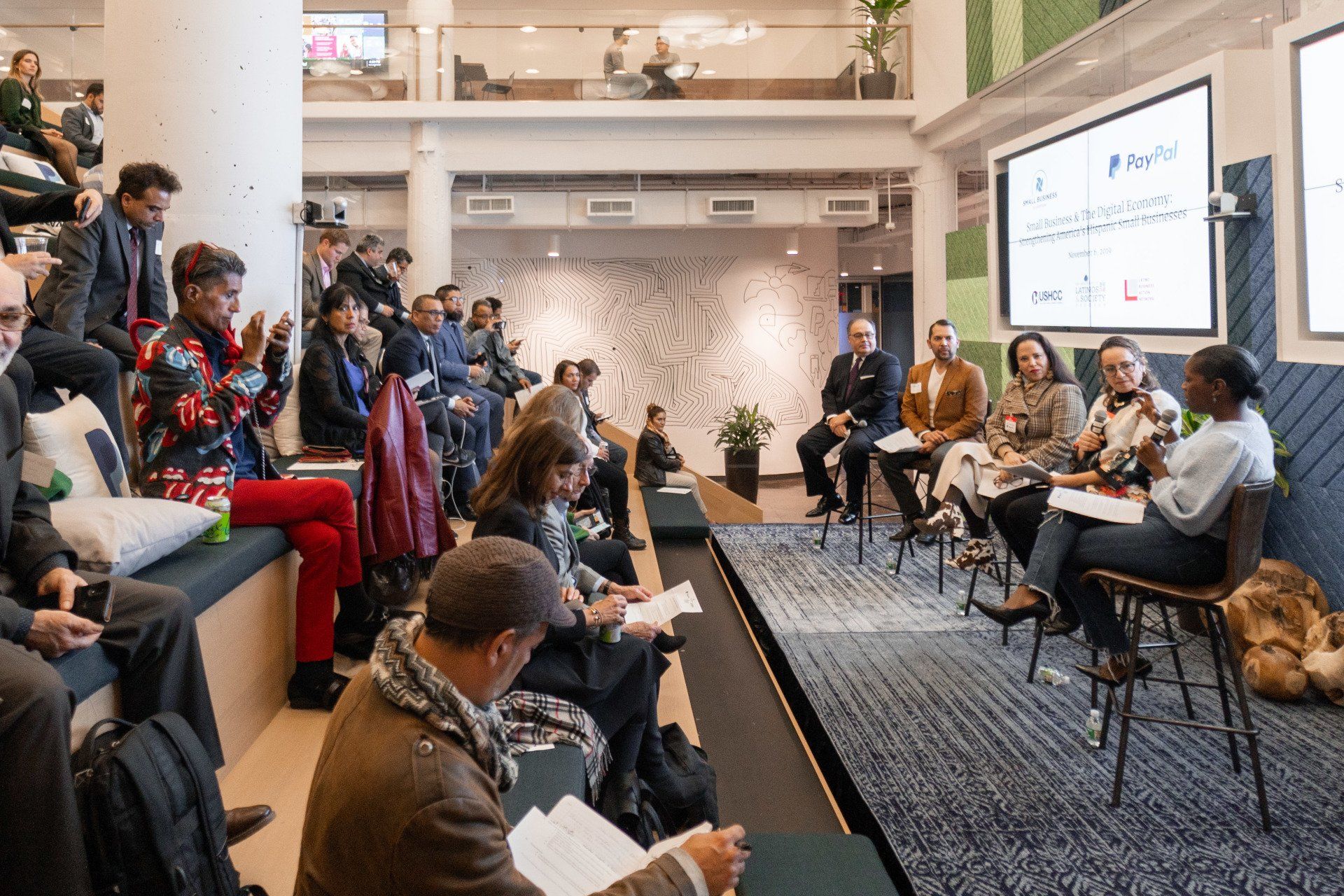 A group of people are sitting in a room watching a presentation.