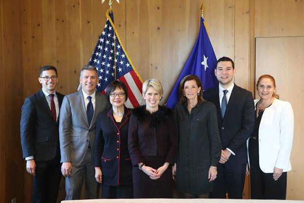 A group of people standing in front of an american flag