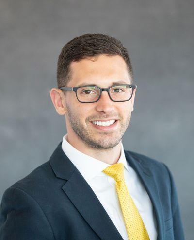 A man in a suit and tie is smiling for the camera.
