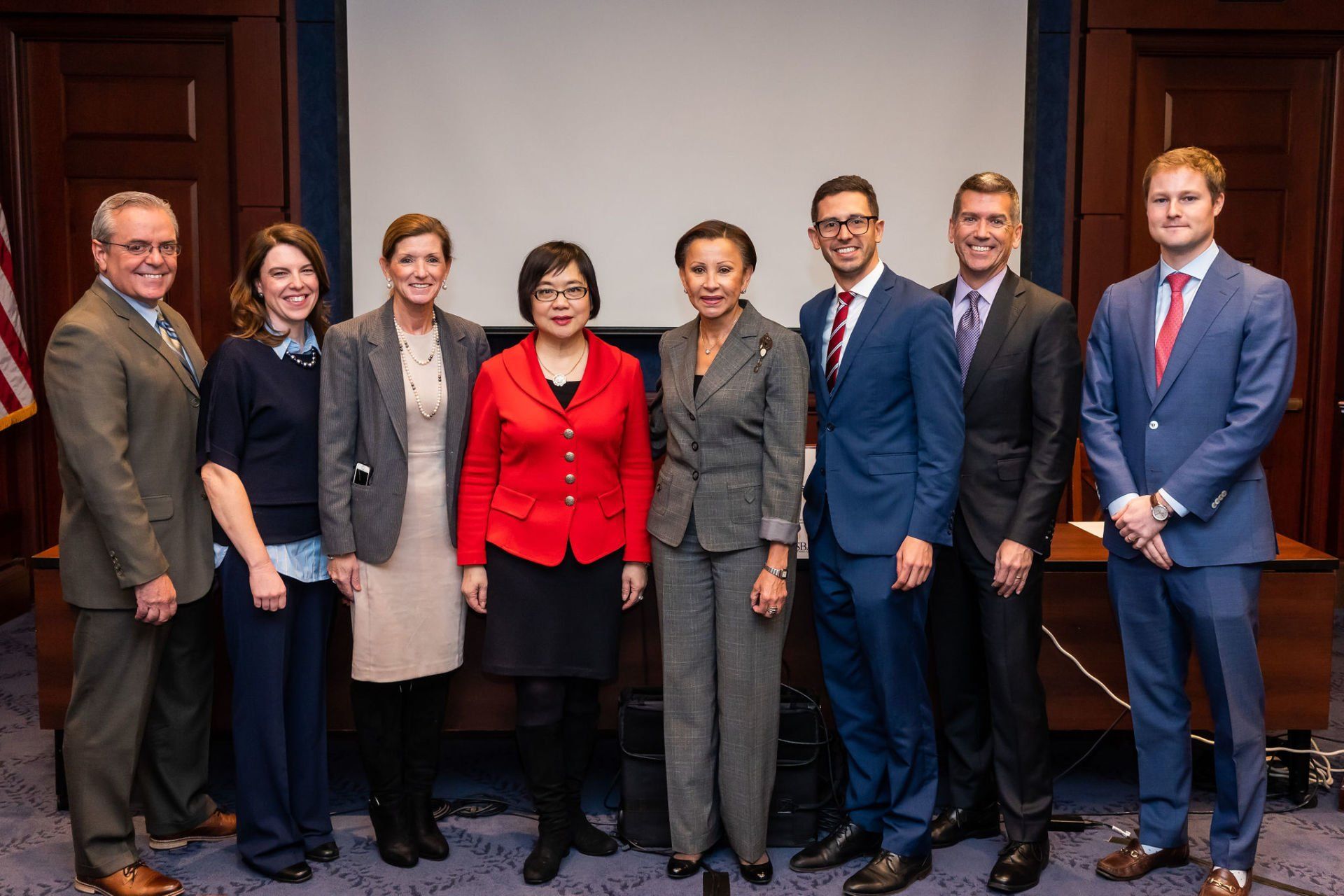 A group of people in suits and ties are posing for a picture.