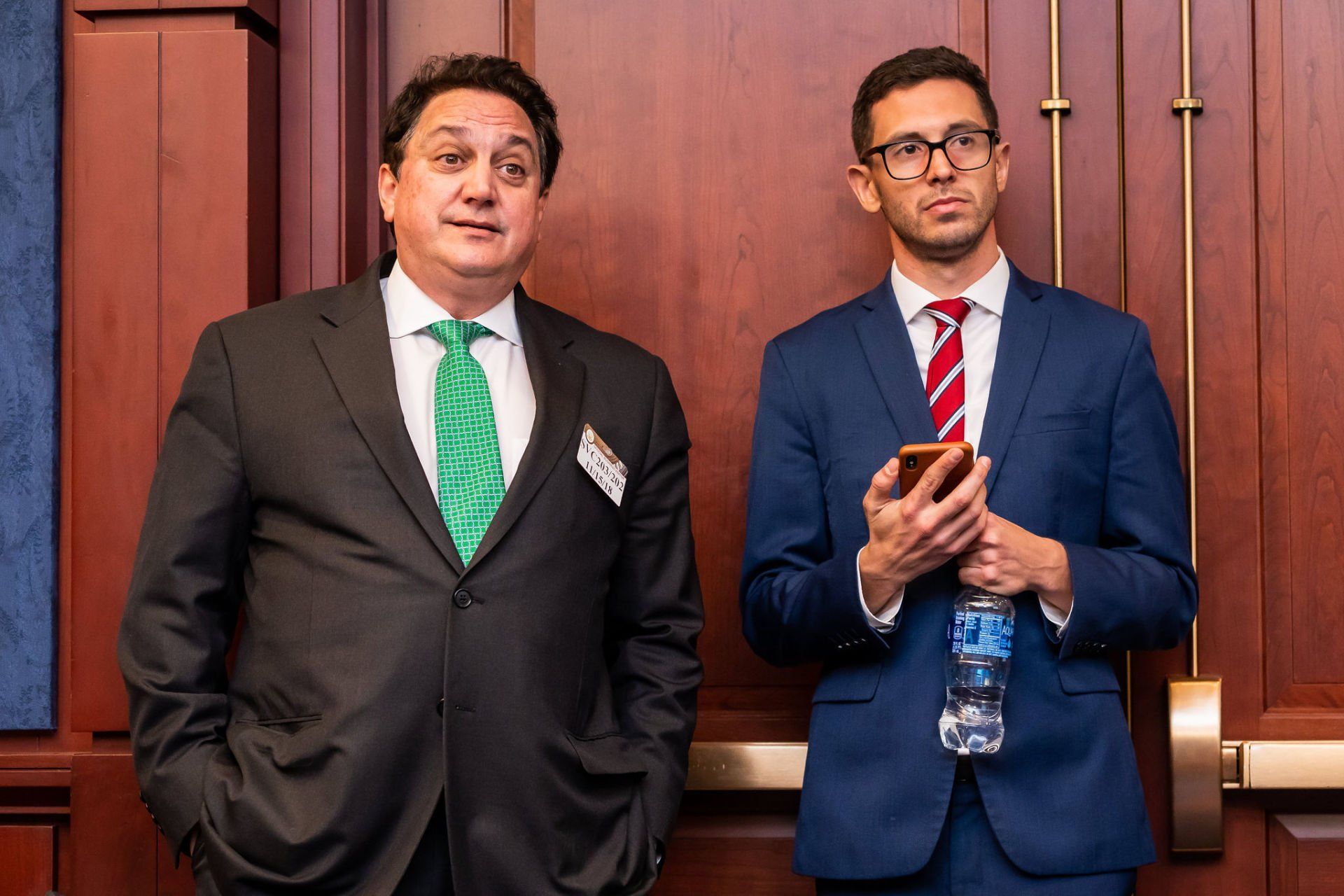 Two men in suits and ties are standing next to each other.