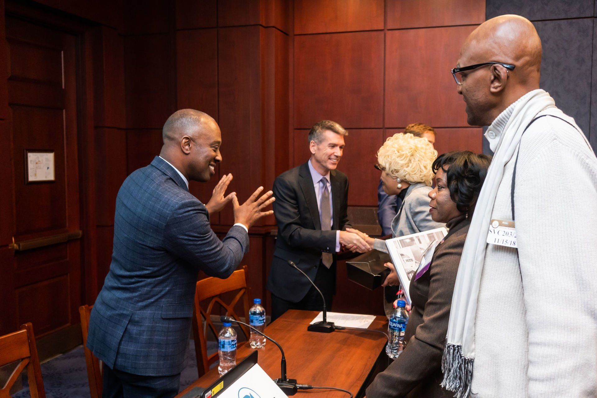 A group of people are shaking hands in a room.